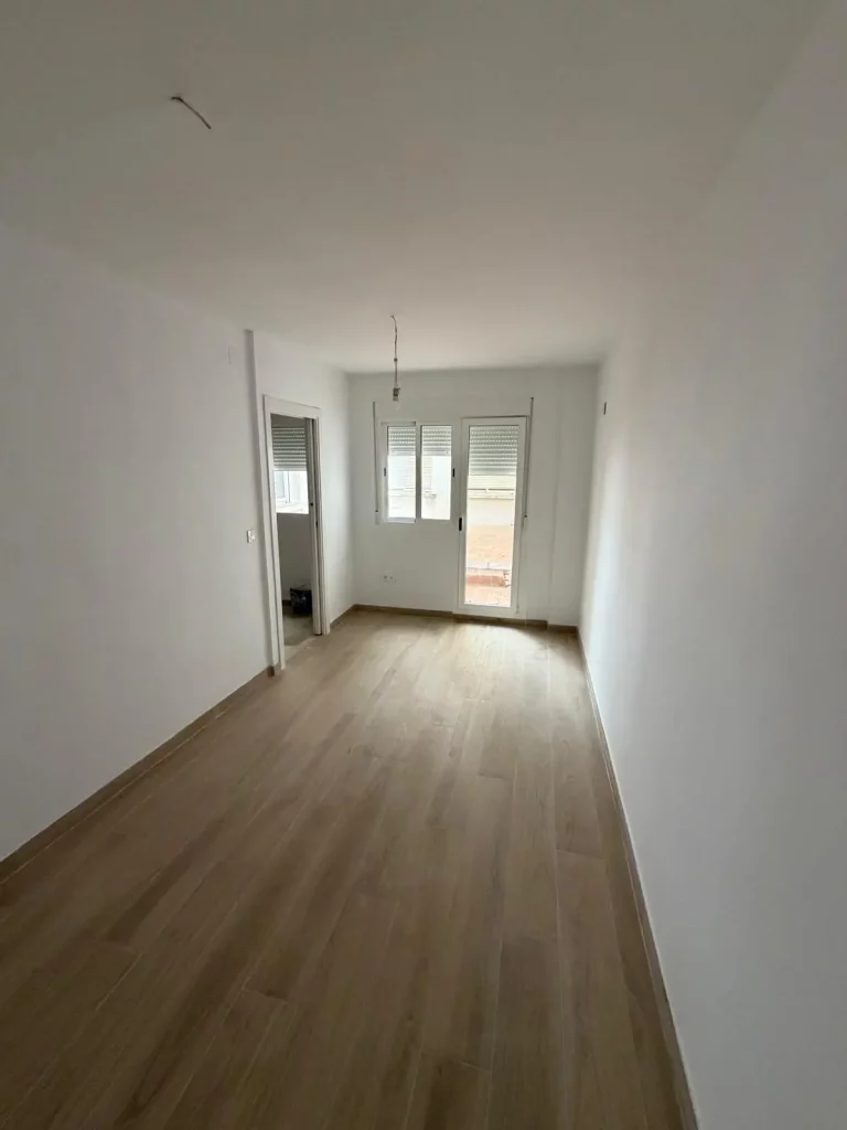 Dormitorio amplio y luminoso con acceso directo a patio interior, grandes ventanales, paredes en tonos claros y espacio ideal para descanso. Habitación tranquila con buena ventilación y luz natural