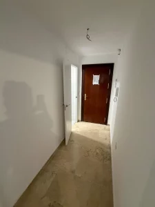 Pasillo distribuidor con acabado moderno, buena iluminación y suelo de alta calidad. Conecta de forma cómoda y eficiente las distintas habitaciones de la vivienda